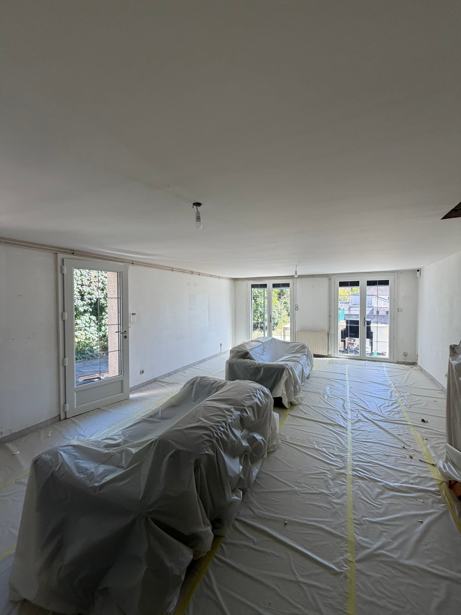 Salon/séjour détapissé, murs et plafond très abîmés