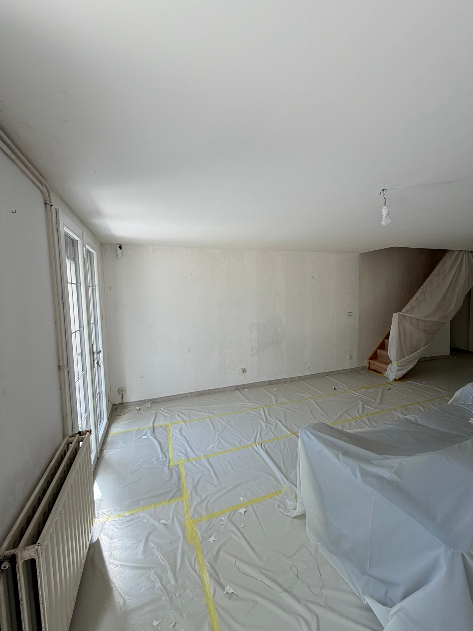 Salon/séjour détapissé, murs et plafond très abîmés