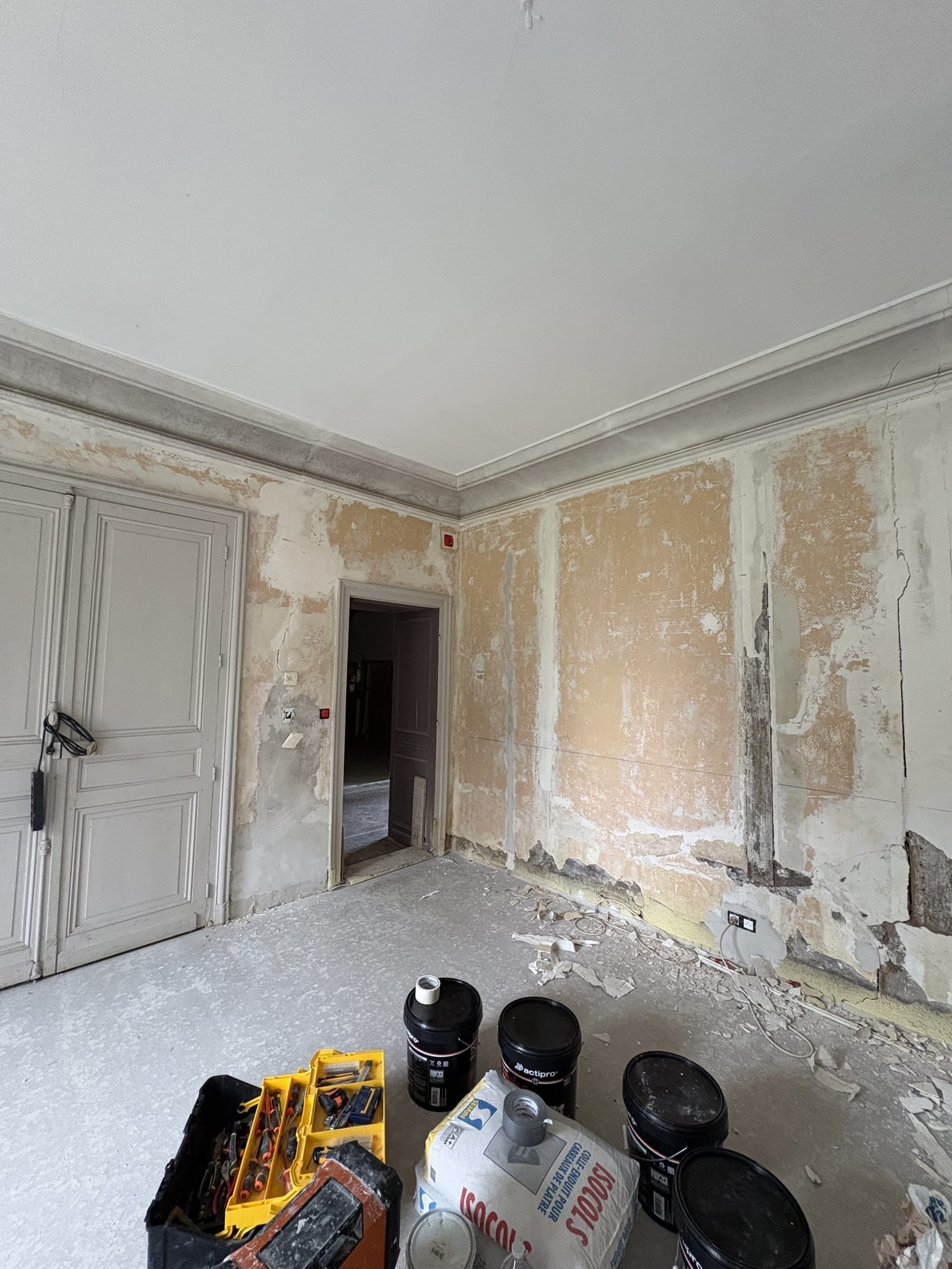 Pièce ancienne avant travaux, plâtres et moulures abîmés, chantier de rénovation à Bourges
