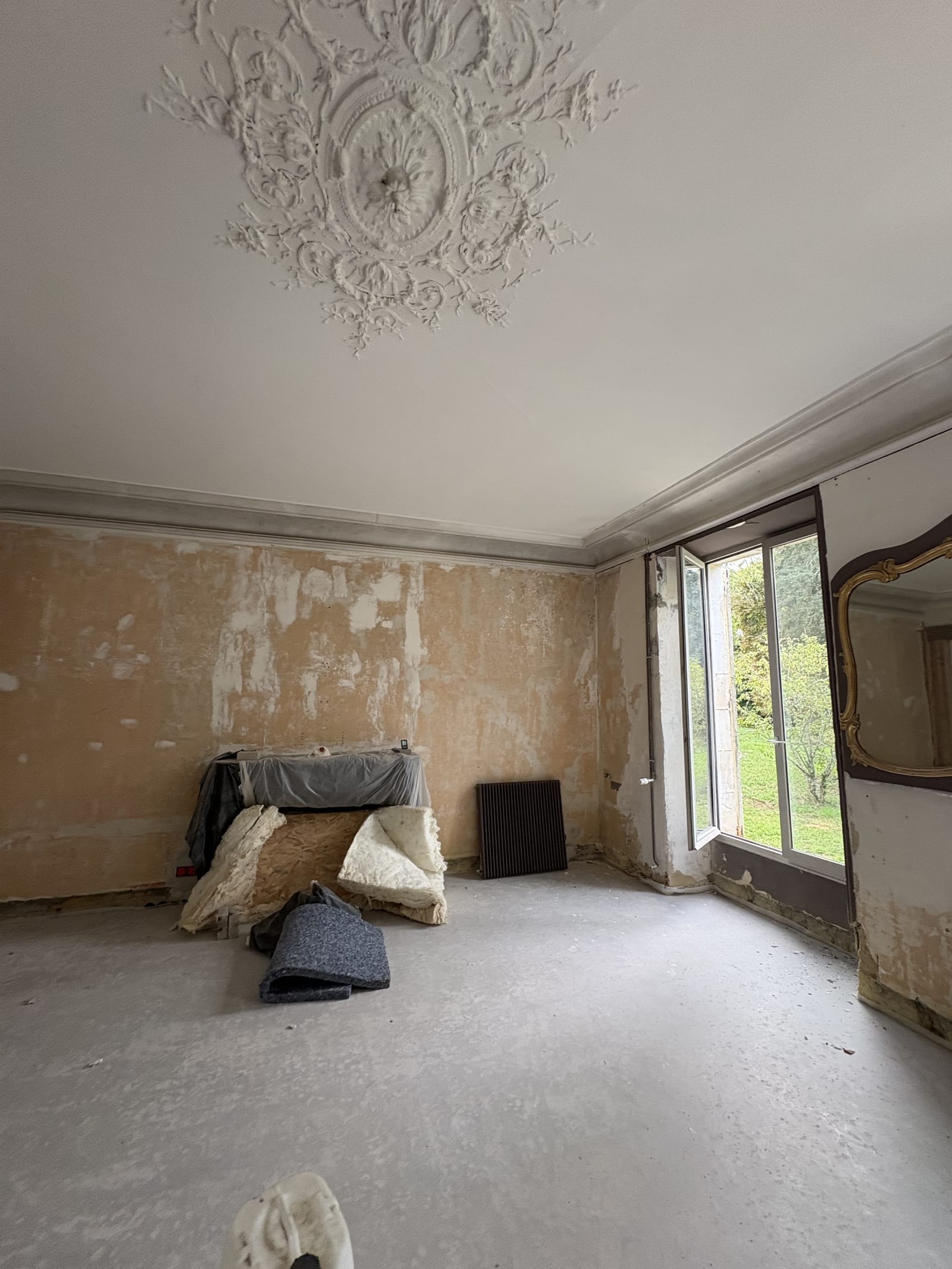 Grande pièce avant rénovation, enduits dégradés et rosace de plafond, chantier à Bourges